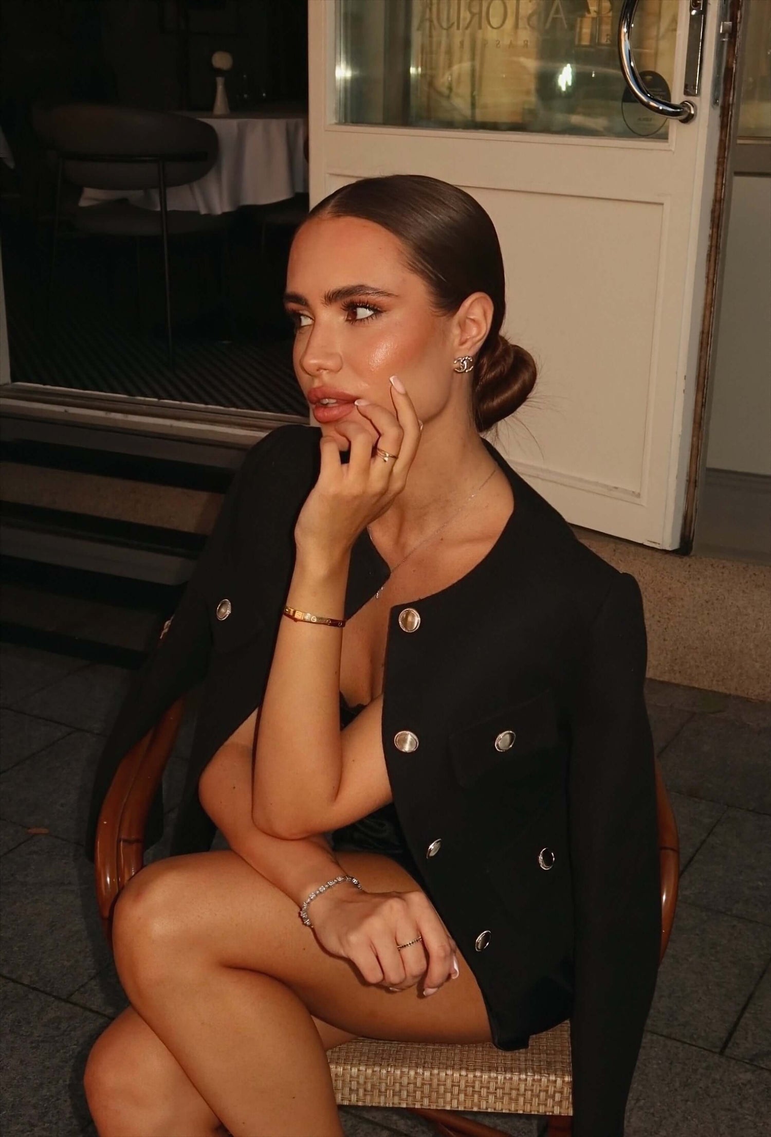 Woman in a black coat sitting on a chair indoors Vilnus